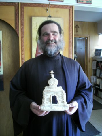 Fr Seraphim holding an artists rendition of our new church!